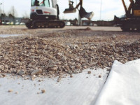 Pemasangan non-woven geotextile sebagai separator kerikil dengan tanah.