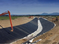 Instalasi geomembrane pada saluran air.