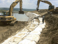 Proses pemasangan geobag di pinggiran sungai.